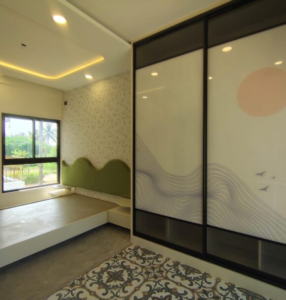Nature-themed bedroom with scenic sliding wardrobe, black framed glass panels, flowing hill line artwork, peach sun motif, bird accents, green wave headboard, patterned flooring, and warm ceiling lighting.